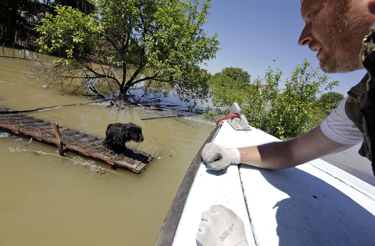 merosezah:  1. A Serbian rows a boat past flooded ambulance vehicles in the flooded