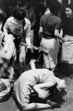colecciones:  Japan’s youth in revolt: a Tokyo Beatle plays guitar as a fan limbos on the floor. Photo by Michael Rougier.