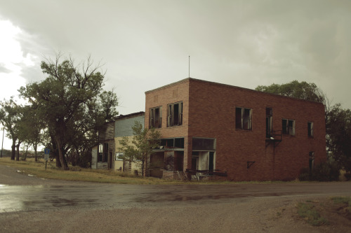 kylejthompson:  I found a ghost town while driving though the midwest. I spent the day wading through dead grass and exploring the vacant homes.  A rusty water tower lay on the outskirts of the town and the yards were littered with old cars.  New life