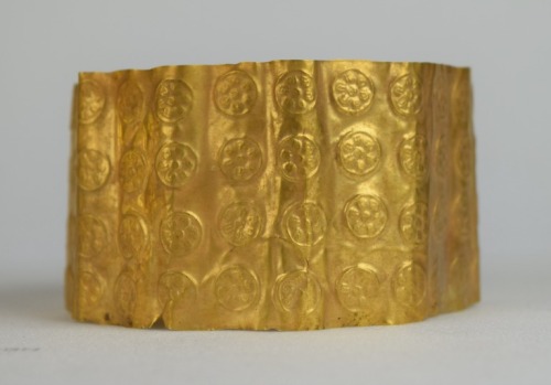 Cypriot gold arm band featuring rows of circles with 5-petaled flowers, c. 1300 BCE. From the collec