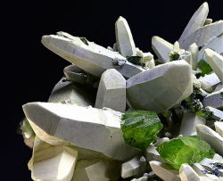 underthescopemin:  Titanite, Quartz (Var: Rock Crystal) Wonderful paragenesis: Rock Crystals with a white coating give the ideal contrast to green Titanites. Rudolf Hasler’s Photo