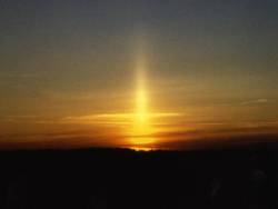 sixpenceee:  A sun pillar is a vertical shaft of light extending upward or downward from the sun. Typically seen during sunrise or sunset, sun pillars form when sunlight reflects off the surfaces of falling ice crystals associated with thin, high-level