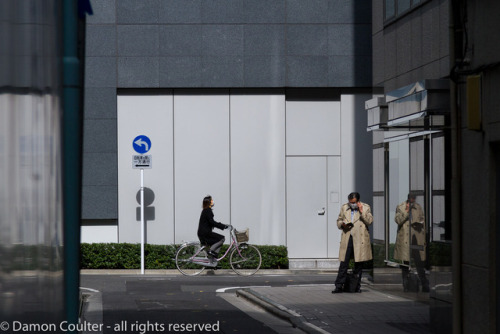 A Salaryman or male office worker makes a phone call in a back street near Ginza in Tokyo, Japan Fri