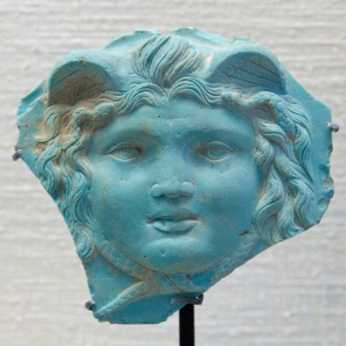 Ancient Roman gorgoneion made of opaque glass paste.  Artist unknown; 1st-2nd cent. CE.  Found at Ro