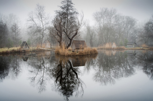 landscape-photo-graphy:Abandoned Fishing Village Outside of Budapest is Perfectly Reflected on the Lake by Viktor Egyed A few miles outside of Budapest lays a small abandoned fishing village composed of rustic huts, tall trees and an obscure atmosphere.