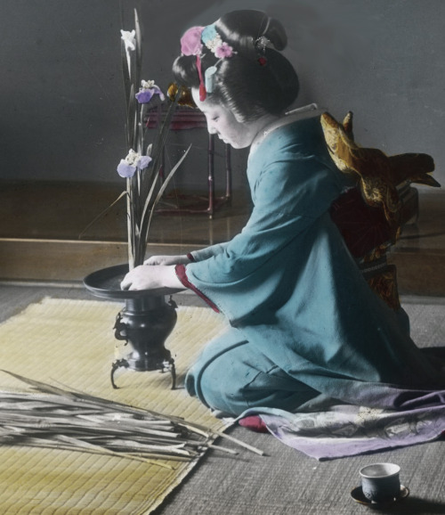 Hand-colored photo of a woman working on her &lsquo;Ikebena&quot; (flower arrangement).  Early 20th 