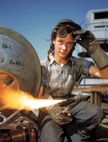 suicideblonde:  A welder at a boat-and-sub-building yard adjusts her goggles before
