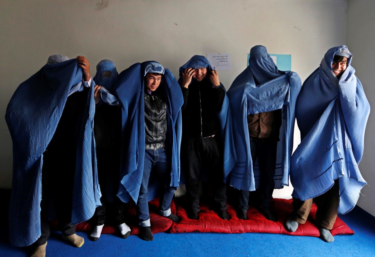 Derechos de las mujeres afganas. Un grupo de hombres afganos marcharon por la capital, Kabul tapados con burkas, que simbolizan la opresión de la mujer, en los días previos al Día Internacional de la Mujer. REUTERS