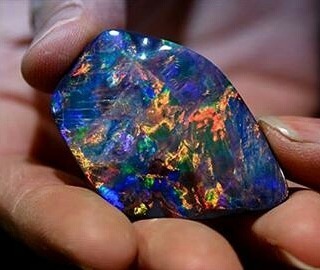 Opal cutter Justine Buckley holds a 92-carat Lightning Ridge black opal that she cut.