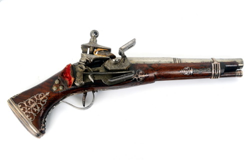 A silver decorated Spanish miquelet pistol dated 1710.