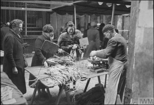 Everyday life in liberated Paris (spring 1945):A large group of civilians queueing outside a bakery-