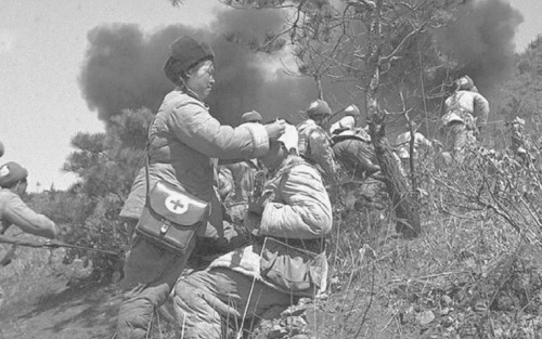 georgy-konstantinovich-zhukov:“A female Chinese medic tends to a wounded soldier as his comrades adv
