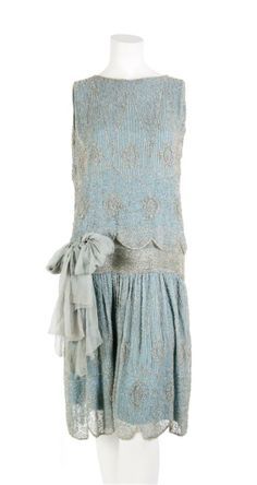 Cocktail dress ca. 1920s. Blue silk chiffon, beaded all over. Sash at dropped waist; fully lined.