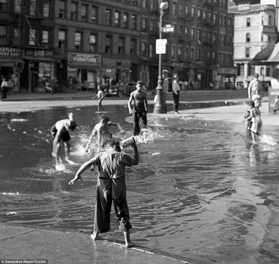 Genevieve Naylor. Cooling off: Dozens of children play in a water-filled 104th street in Harlem during 1939. From Genevieve Naylor/Corbis
