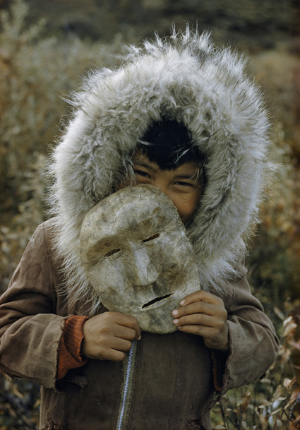 global-musings:Young boy in fur holding maskLocation: Alaska, United StatesPhotographer: Thomas Aber