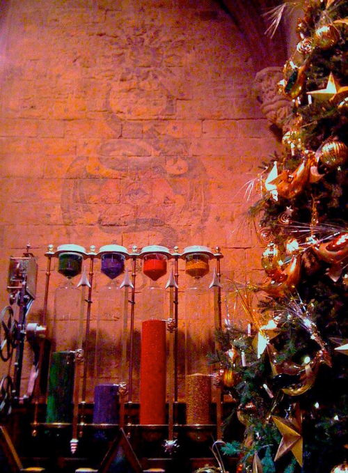 Christmas tree on display beside the House Cup hourglasses in the Great Hall of Hogwarts School of W