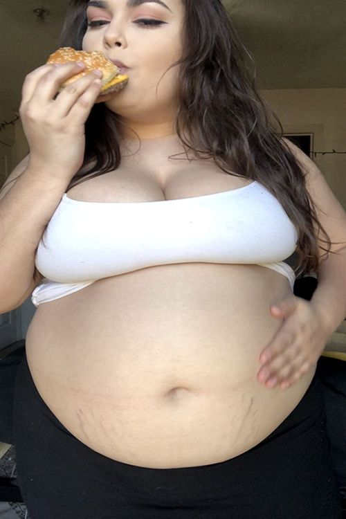 neptitudeplus:In an hour she’ll stand at the booth where fair-goers pay to guess how many burgers she’s stuffed into her swollen belly. What’s your guess so far?