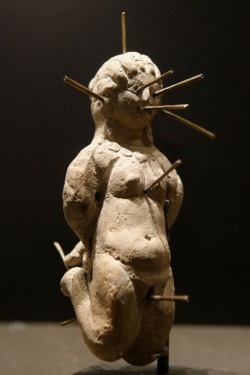 thegorean:  Nude female voodoo doll in kneeling position, bound and pierced with thirteen pins. Found in Egypt in a terracotta vase with a lead tablet bearing a  binding spell (katadesmos). 4th century AD