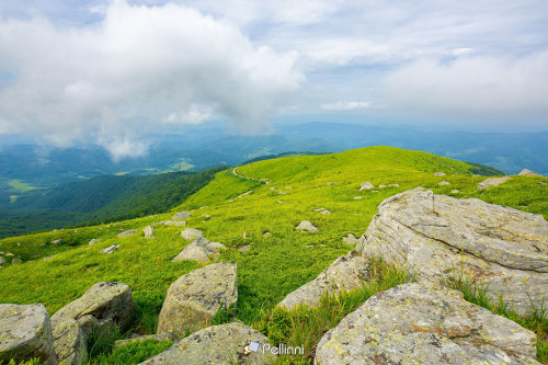 view from runa mountain. huge stones on the grassy slopes. summer landscape of carpathian mountains.
