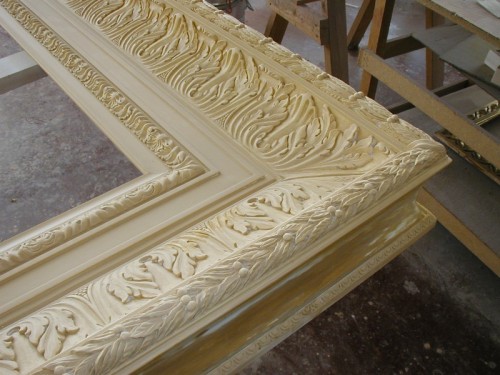 This reproduction of a 19th century frame was carved entirely by hand. The moulding is 12 inches wide and is finished in 22k gold leaf over yellow clay with red highlights. The pictures above show some of the steps during production.