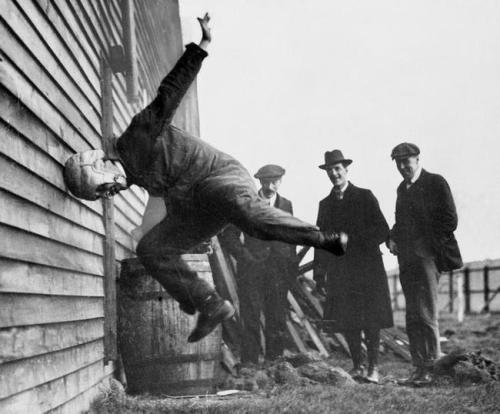 A man tests a prototype football helmet, 1912.