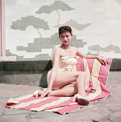 s-h-o-w-a: Japanese actress Mie Kitahara posing in a swimsuit sitting on a beach towel, Japan, late 