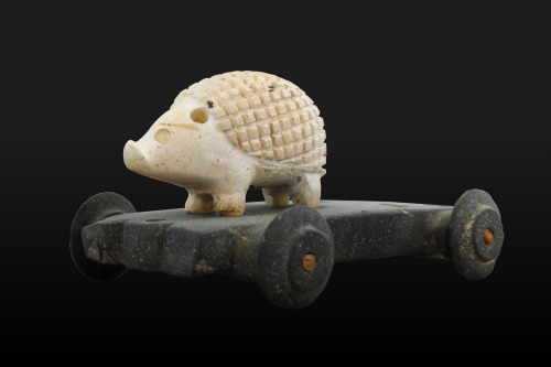 tinybed:museum-of-artifacts:A wheeled asphalt and limestone hedgehog statuette, Iran (3500 years old