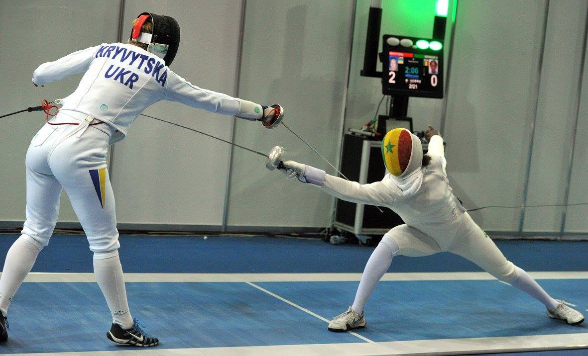 modernfencing:  [ID: an epee fencer lunging and hitting her opponent.]  				Olena