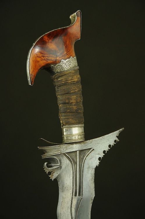 art-of-swords:  Moro Keris SwordDated: 19th centuryCulture: IndonesianMedium: iron, silver, rope, woodMeasurements: overall length 29.25 inches (74.3cm); blade length 22.75 inches (57.8cm)The sword’s pommel measures 4.5 inches from tip to top and is