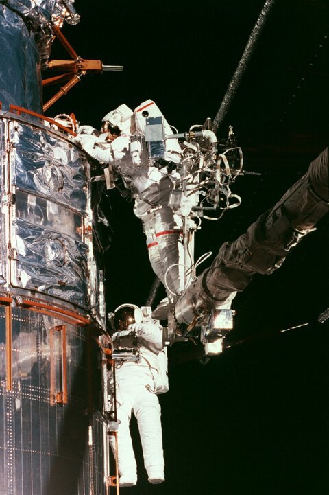 cosmonautoncall:  During STS-82’s Hubble servicing mission, astronauts Lee and Smith patch the telescope’s worn insulation 
