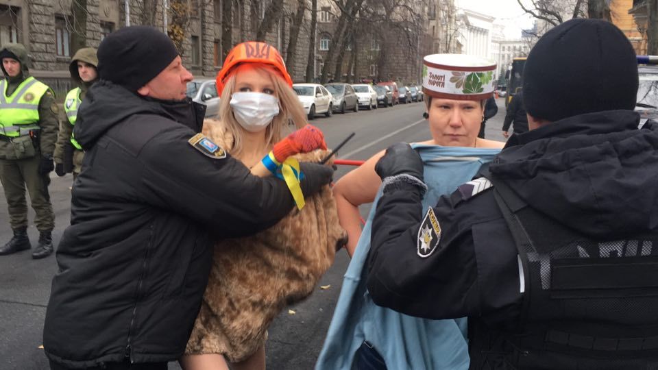 PROTESTA EN KIEV. Policías detienen a activistas en topless del grupo de derechos de las mujeres Femen durante una protesta contra el presidente ucraniano Poroshenko en Kiev, Ucrania, el cuarto aniversario de la Revolución de la Dignidad....