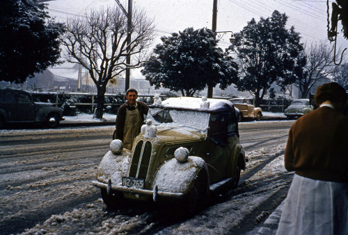Three snowmen atop a car.⁣The vehicle has been identified as a 1949 Ford Anglia E494A tourer.⁣1956⁣⁣