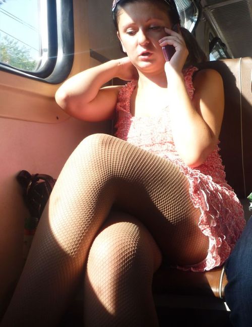 Crossed legs in nude fishnet pantyhose caught in a train.Woman in pantyhose