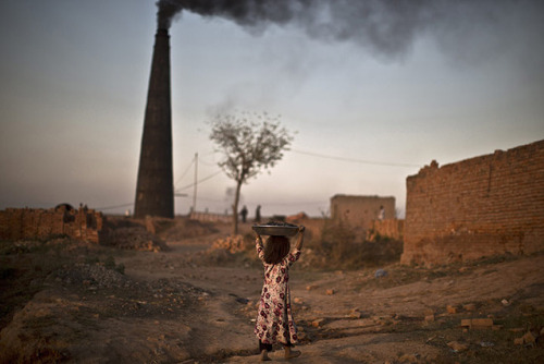 Following her daily work with her parents at a brick factory, Nagina Mohammed, 7, walks back to her 