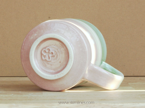 A pink, cream, and green cup. I added drops of white glaze to create an abstract flower pattern on t