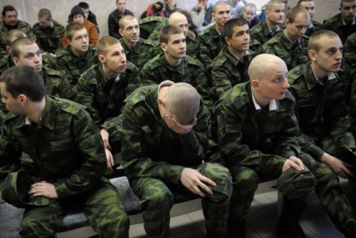 Askeri üniforma giydirilmiş saçları ve sakalları tamamen kesilmiş genç erkekler