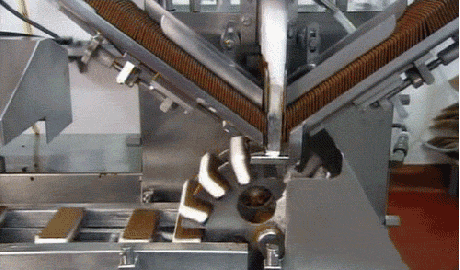 A machine assembles ice cream sandwiches rapidly.