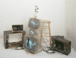 avtavr:  TV Cello, 1971by Nam June PaikWalker Art Center, Minneapolis, USA.Mixed Media, Medium video tubes, TV chassis, plexiglass boxes, electronics, wiring, wood base, fan, stool, photograph extent. video tube in Plex box with removable back cover: