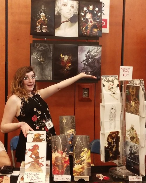 gentlemandeerlord:

And now a completely psychotic picture of me at my table for #VanCaf! Come see me at n5 in the gymnasium!! I’m selling demon road and all kinds of prints :) 