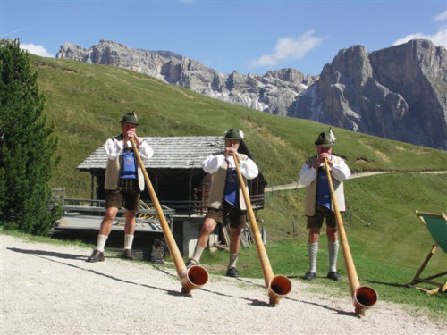 Men playing Alphorns or Alpenhorns (or Alpine horns), a tradition that dates back to the 16th centur