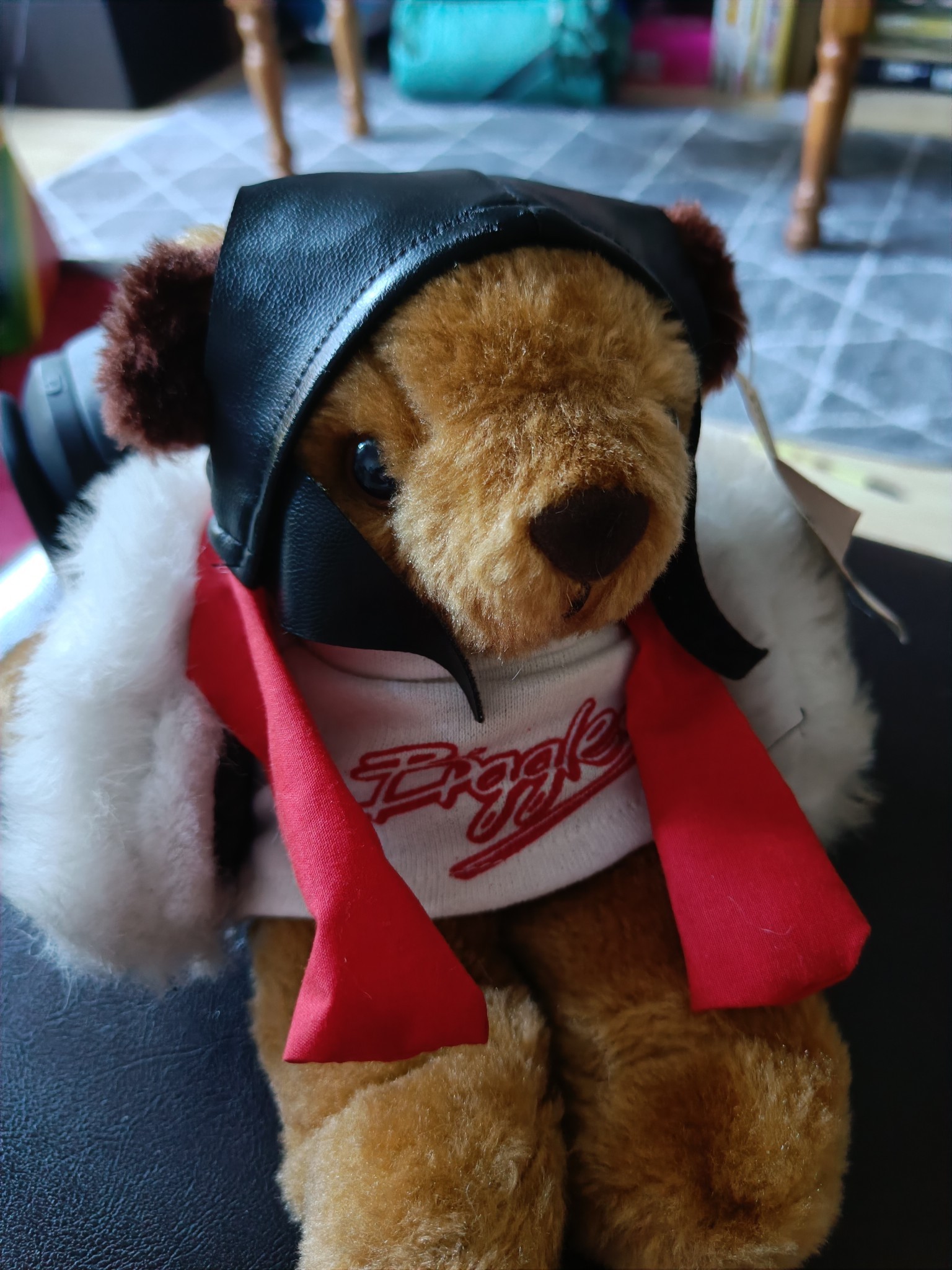 � small teddy bear wearing leather flying kit and a white t-shirt saying 'Biggles' in the movie font.
