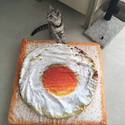 archiemcphee:  On Caturday a hearty breakfast of fried eggs on toast isn’t eaten, it’s napped on as only cats can.Get your own toast cat bed here.[h/t: Pleated-Jeans]
