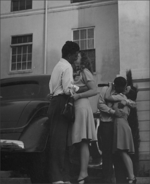 Couples embracing in front of city hall after exchanging vows. 1940