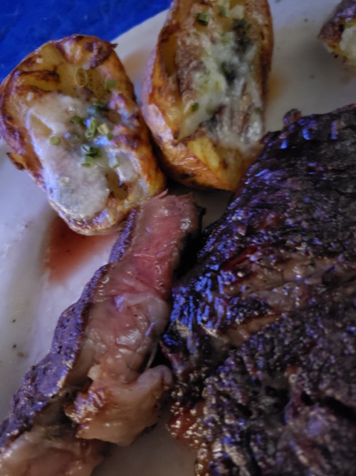 You might not hear it for a bit, but I got back into the recording booth today, so I made myself a little victory dinner. Ribeye with English Jacket potatoes, whole thing under 8 bucks, beautifully pink on the inside with that full char. If nothing else,