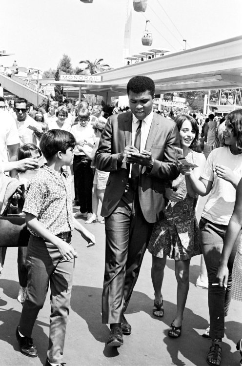 aintknow: Muhammad Ali at Disneyland signing autographs as he makes his way through Tomorrowland.