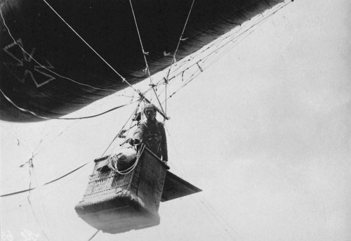 A German observer shoots off light signals with a pistol from a balloon (WW1).