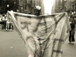 funkpunkandroll84: Marsha P. Johnson at a Christopher Street Liberation rally with a curtain that has the words GAY LOVE written all over it, c. 1970s