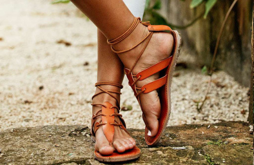 Strappy, lace up leather sandals on pretty feet.