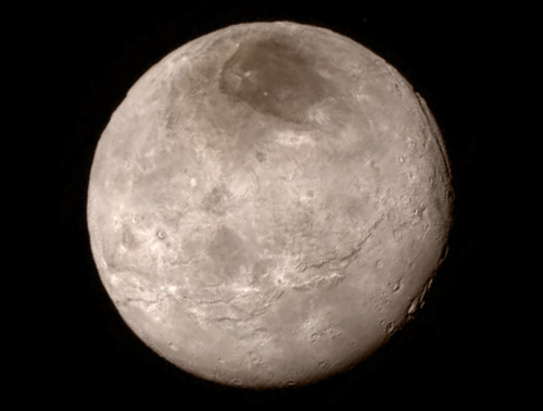 At long last, and for the first time, the surface of Pluto. And the first high-resolution photograph