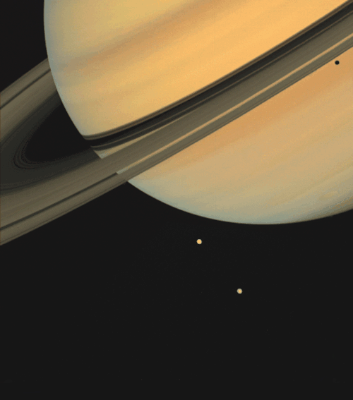 humanoidhistory:Planet Saturn and its moons Tethys and Dione were, photographed by the Voyager 1 spa